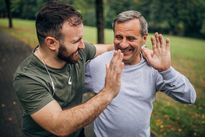 Man and son exercising in park together