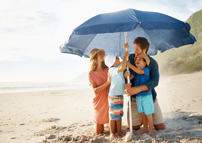 Family on the beach under an umbrella image