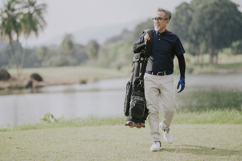 golfer carrying a golf bag