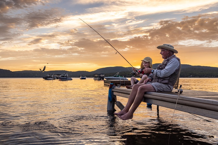 Grandfather and Grandson Fishing At Sunset